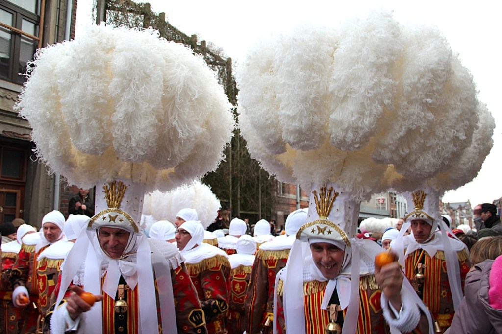 Men dressed as Gilles with ostrich feathers