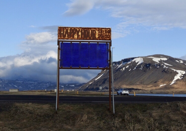 A dilapidated happy hour sign